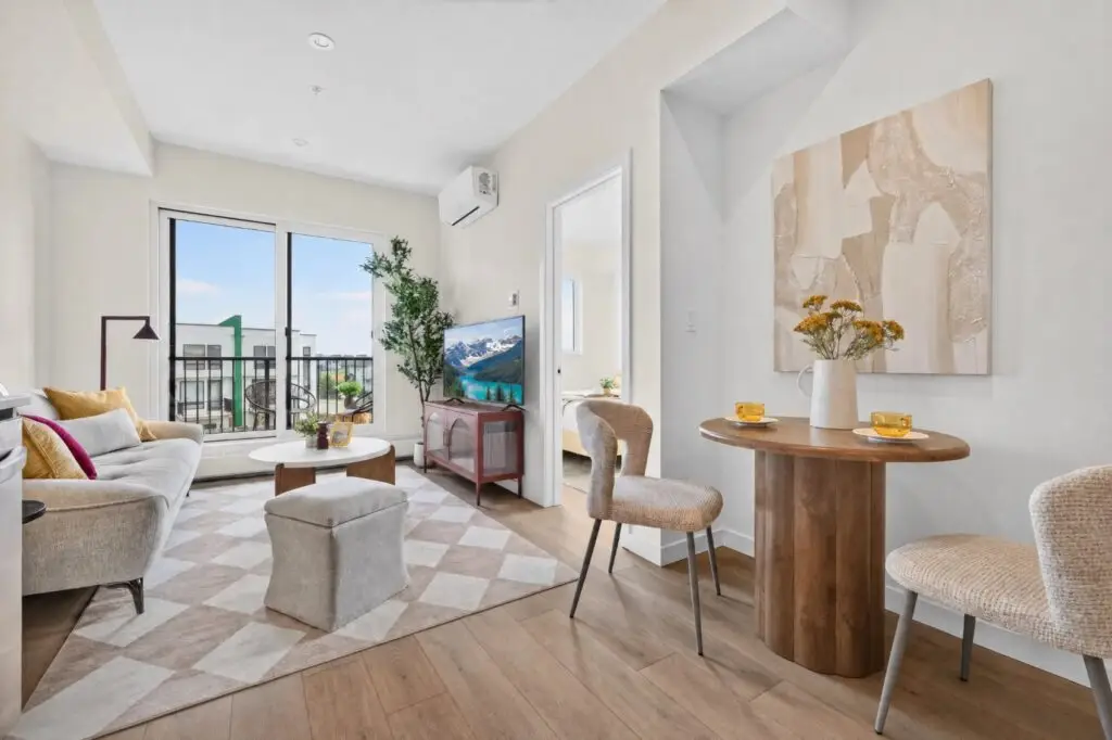 Open living and dining area with balcony doors and the bedroom beyond